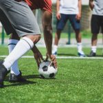 partial view of group of soccer players during soccer match on pitch